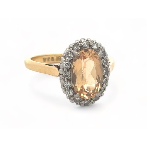 27 - An oval imperial topaz and diamond cluster ring, stamped 18ct and PLAT, by maker W.E.G. Topaz approx... 