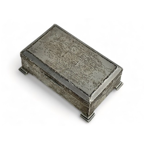 114 - A small rectangular silver trinket box with engine turned design, on four feet with a wood lined int... 