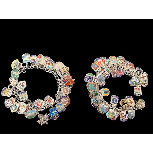 40 - Two vintage silver charm bracelet with silver and enamel travel shields. Approx 72 charms in total.
... 