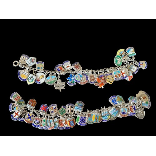 40 - Two vintage silver charm bracelet with silver and enamel travel shields. Approx 72 charms in total.
... 