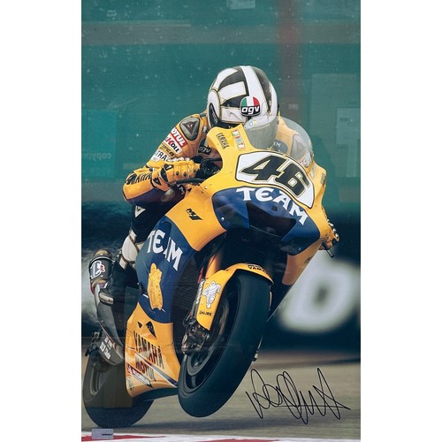 416 - Framed signed Valentino Rossi picture. Valentino Rossi on his yellow Yamaha motorbike, this image is... 