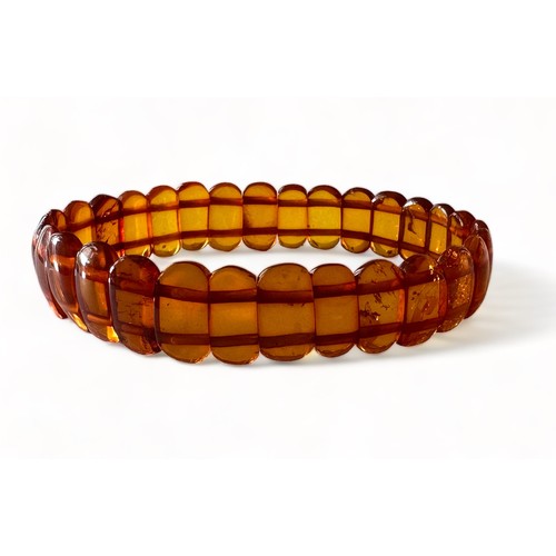 31 - An amber bracelet comprised of shaped amber cabachons attached to two strings of elastic.

Please se... 