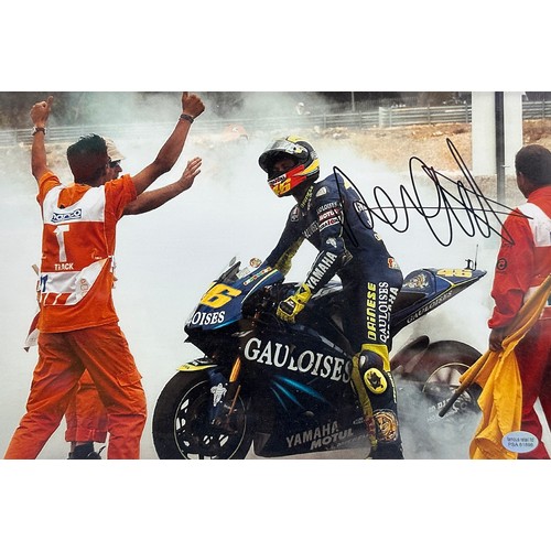 422 - Framed signed Valentino Rossi race win picture. Rossi performing a burnout after a race win. COA sti... 