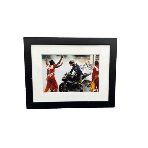 422 - Framed signed Valentino Rossi race win picture. Rossi performing a burnout after a race win. COA sti... 