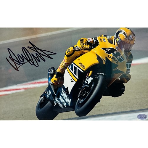 423 - Framed signed Valentino Rossi picture. Rossi pictured cornering on his yellow Yamaha motorbike. COA ... 