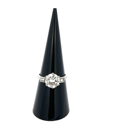 37 - A diamond solitaire ring, estimated 2.32ct with baguette diamond shoulders. Diamond is lively. Size ... 