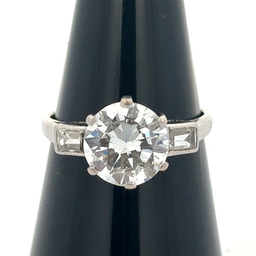 37 - A diamond solitaire ring, estimated 2.32ct with baguette diamond shoulders. Diamond is lively. Size ... 