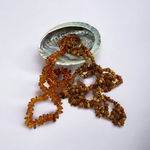 40A - A long (approx 200cm) amber chip necklace, a faux amber necklace and an abalone shell -