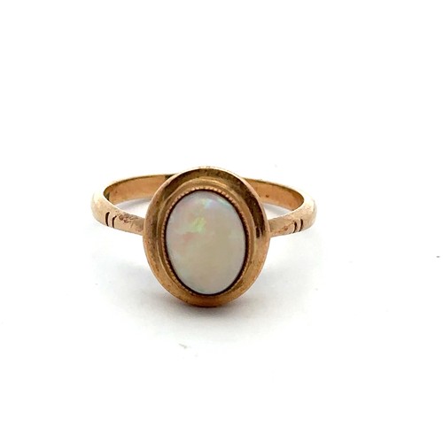 34 - A gold and opal ring, stamped 9ct. Size O/P. Opal 9mm x 7mm and showing all colours of the spectrum ... 