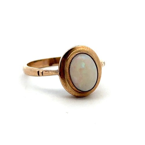 34 - A gold and opal ring, stamped 9ct. Size O/P. Opal 9mm x 7mm and showing all colours of the spectrum ... 