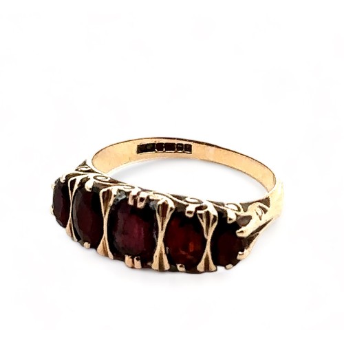 48 - A hallmarked 9ct gold five stone garnet ring with scroll decoration, size O.  3.2g.