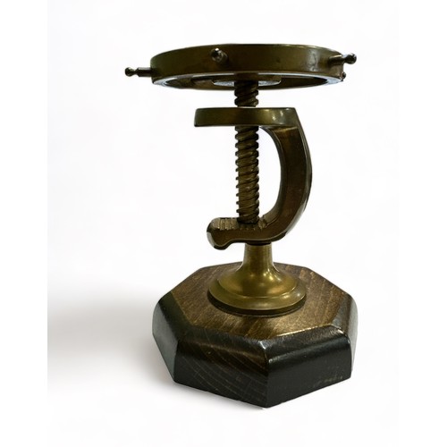 109 - Brass Ships Wheel in the form of a nutcracker mounted on a wooden stand. Working order.