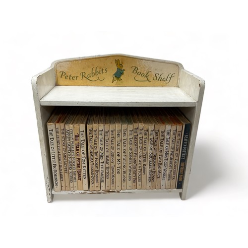 452 - A wooden Peter Rabbit Book Shelf containing 25 Beatrix Potter books.