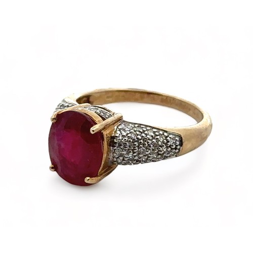 22 - A 9ct yellow gold ring set with a central ruby and diamond shoulders. Size N. Weight 3.8g. In excell... 