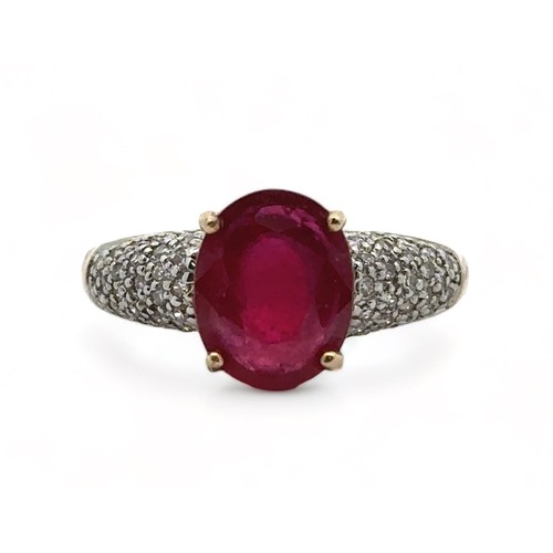 22 - A 9ct yellow gold ring set with a central ruby and diamond shoulders. Size N. Weight 3.8g. In excell... 