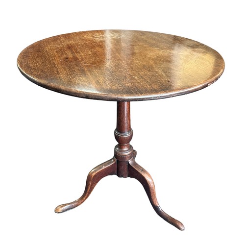 476 - A late 18th Century mahogany tripod table. Having a circular hinged tilt top over a turned central c... 