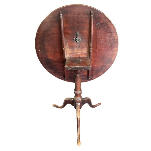 476 - A late 18th Century mahogany tripod table. Having a circular hinged tilt top over a turned central c... 