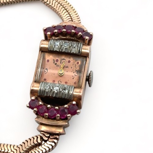 104 - A ladies Bulova rose gold cocktail watch set with six single cut diamonds and ten rubies surrounding... 