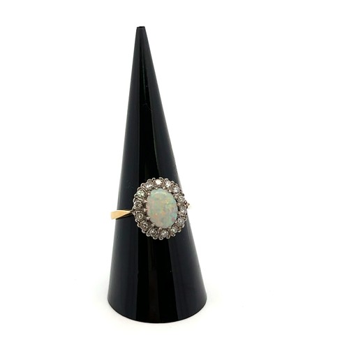 36 - An 18ct yellow gold, opal and diamond ring. Opal (approx 9mm x 6mm) with full spectrum of colour sur... 