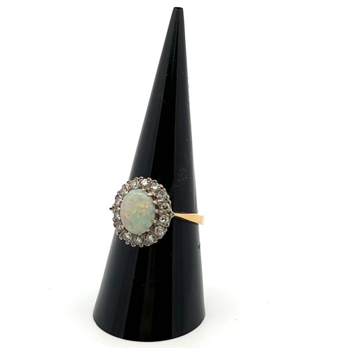 36 - An 18ct yellow gold, opal and diamond ring. Opal (approx 9mm x 6mm) with full spectrum of colour sur... 