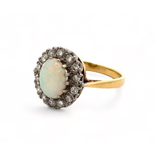 36 - An 18ct yellow gold, opal and diamond ring. Opal (approx 9mm x 6mm) with full spectrum of colour sur... 