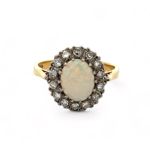 36 - An 18ct yellow gold, opal and diamond ring. Opal (approx 9mm x 6mm) with full spectrum of colour sur... 