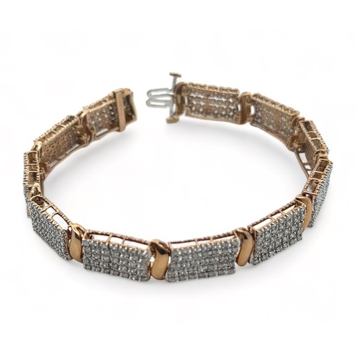 49 - A 9ct gold and diamond bracelet. Each of the eleven main links is set with 35 diamonds.  Length appr... 