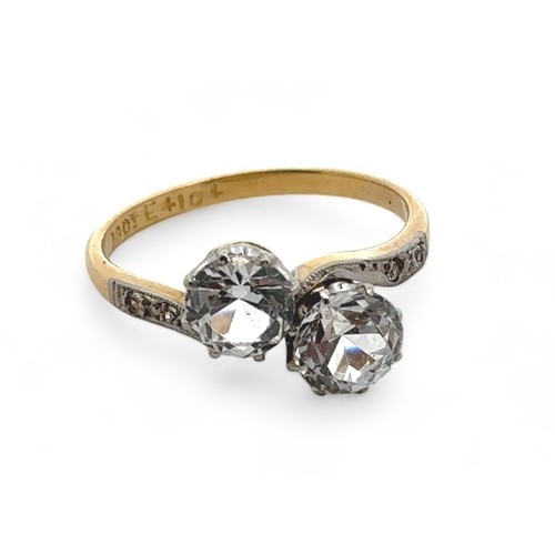 56 - A zircon crossover ring stamped 18ct. Size R.

Please see the buyer's terms and conditions for purch... 