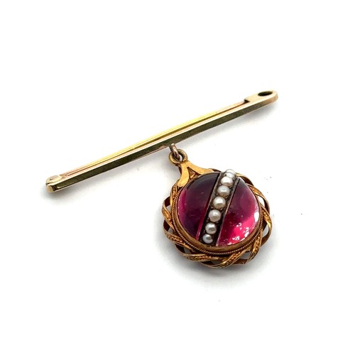 59 - A bar brooch with a red cabochon and seed pearl pendant in a twist surround mount suspended from it.... 