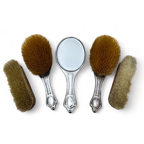 141 - An Edwardian Art Nouveau five piece silver mounted dressing table set comprising of a hand mirror an... 