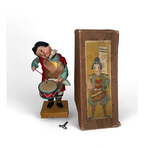 465 - Japanese Drummer clockwork with key doll on wooden base, generally good to good fair (head part deta... 