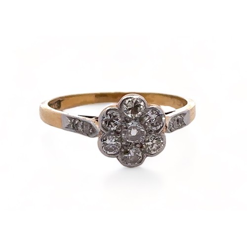 27 - An 18ct gold and diamond flower head cluster ring. Seven brilliant cut diamonds, the central diamond... 