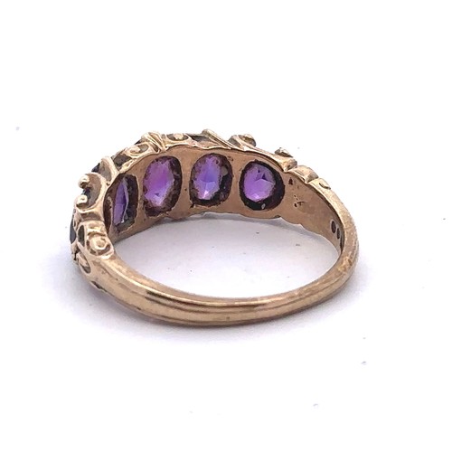 29 - A 1960s five stone amethyst ring set in 9ct gold with scroll shoulders, size N. Sponsor S&KH. Weight... 