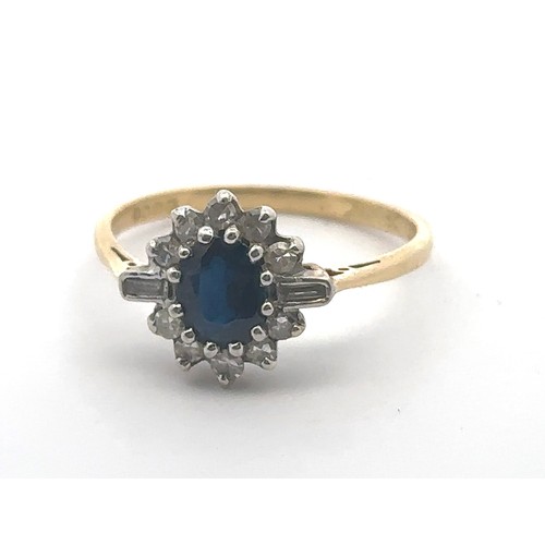 31 - An 18ct gold, sapphire and diamond cluster ring. Central oval sapphire surrounded by baguette and ro... 