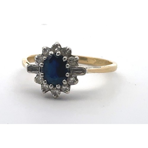 31 - An 18ct gold, sapphire and diamond cluster ring. Central oval sapphire surrounded by baguette and ro... 