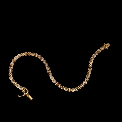 12 - An 18ct yellow gold and diamond tennis bracelet. Estimated total diamond weight 0.8ct. Sheffield imo... 