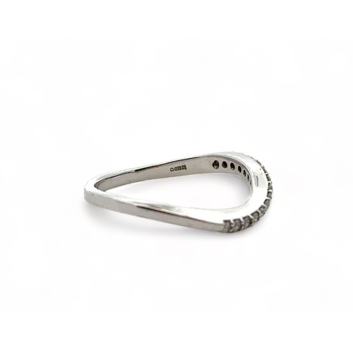 49 - A 9ct white gold and diamond wave shaped half eternity ring, size P. Sponsor CH, London assay mark. ... 