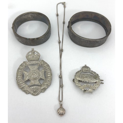 39 - Two silver bangles with foliate decoration and a silver necklace. Also two cap badges (Royal Tank re... 