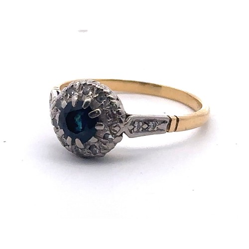 37 - A Sapphire and diamond cluster ring, stamped 18ct. Size P. Weight 3.24g. Sapphire 5mm in diameter an... 