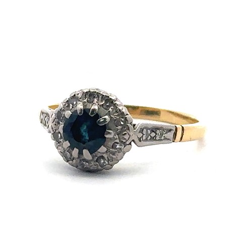 37 - A Sapphire and diamond cluster ring, stamped 18ct. Size P. Weight 3.24g. Sapphire 5mm in diameter an... 