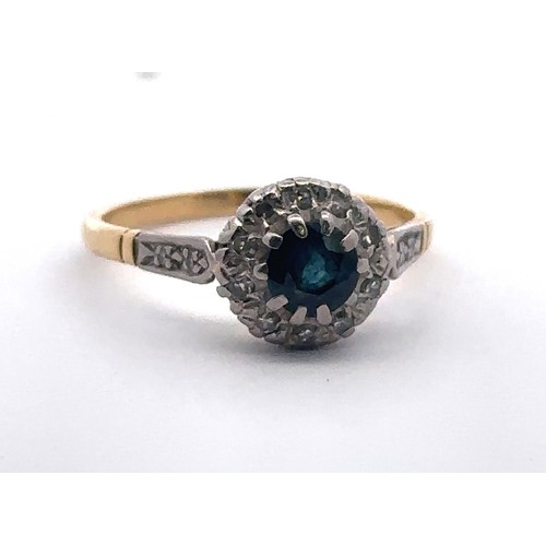 37 - A Sapphire and diamond cluster ring, stamped 18ct. Size P. Weight 3.24g. Sapphire 5mm in diameter an... 