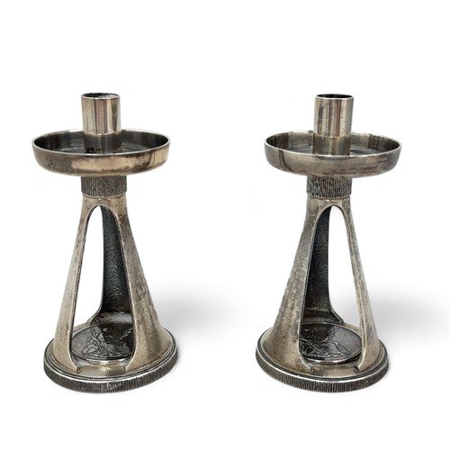 98 - A pair of Christopher Nigel Lawrence candlesticks each with a plain circular sconce on a textured ta... 