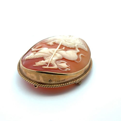 20 - A hallmarked 9ct gold shell cameo brooch with rope twist surround depicting St George killing a drag... 