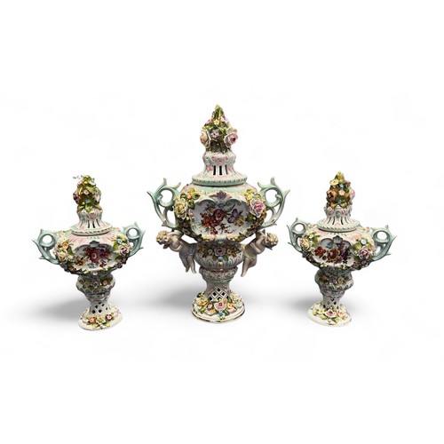 330 - A trio of vases with Sitzendorf marks to base decorated in relief with floral designs and cherubs. H... 