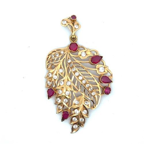 9 - A ruby and white stone (likely topaz) pierced leaf shaped pendant set in unmarked gold, tested using... 