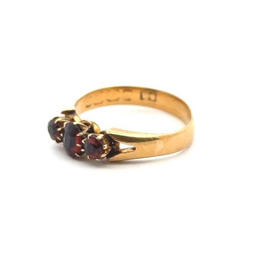 38 - A three stone garnet ring, size O. Hallmarks rubbed and unclear but tested as using XRF as 18ct gold... 