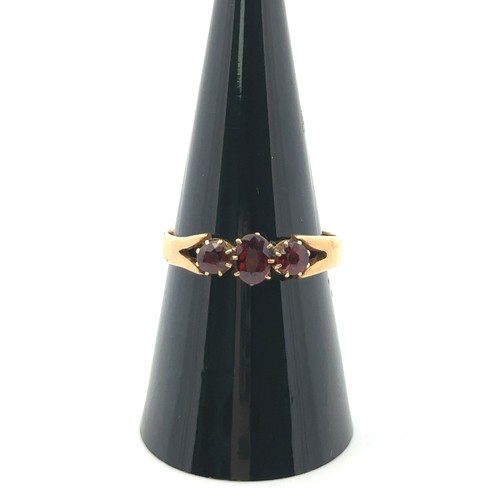 38 - A three stone garnet ring, size O. Hallmarks rubbed and unclear but tested as using XRF as 18ct gold... 