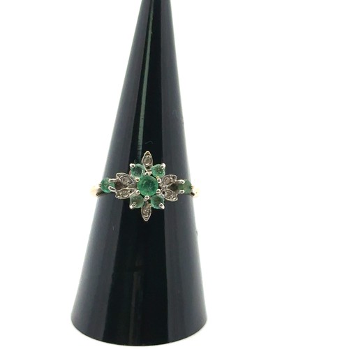 26 - An emerald and diamond cluster ring, size O,  stamped 14ct. Weight 2.53g.