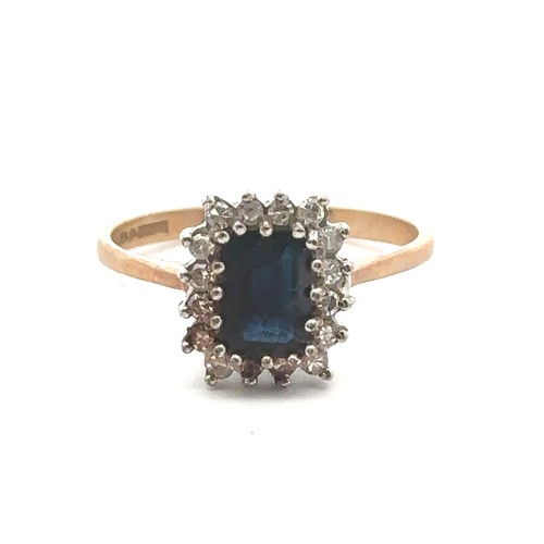 57 - A sapphire and diamond cluster 9ct ring, size P. Sapphire 7mm x 5mm. Weight 2.2g. Condition - there ... 