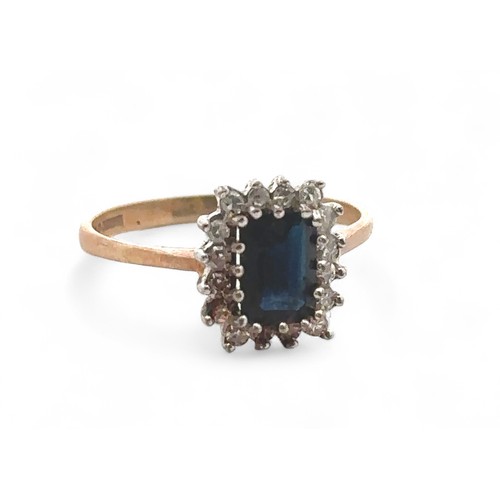 57 - A sapphire and diamond cluster 9ct ring, size P. Sapphire 7mm x 5mm. Weight 2.2g. Condition - there ... 